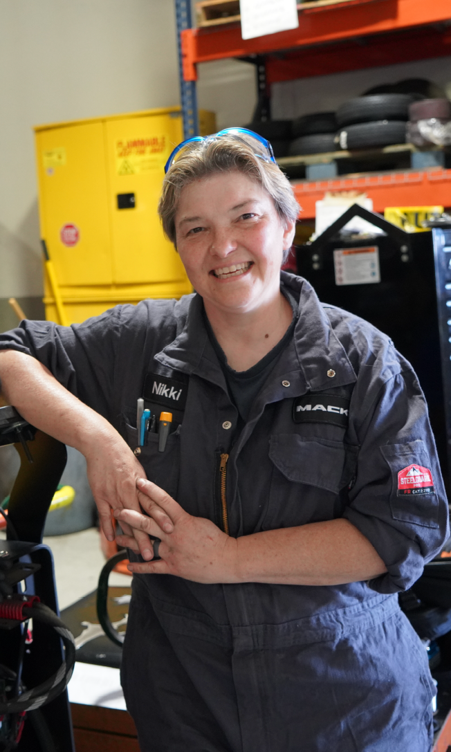 Photo of a female apprentice standing in front of machinery